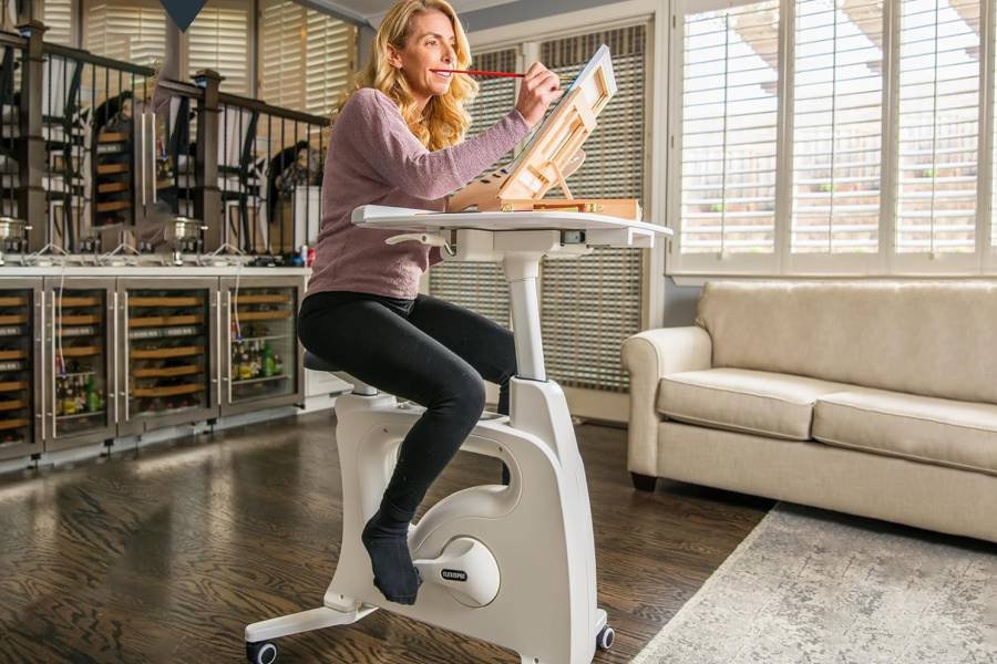 🚴♂️ FLEXISPOT V9 ¡La Máquina Que Trabaja Tus Piernas Mientras Tú Mueves Millones! (O VES MEMES... A SEGÚN) 🤑🦵 14 IMAGEN - LaTachuelaTech - flexispot v9 - Un oficinista joven estilo tech moderno con gafas en bicicleta interior - 07